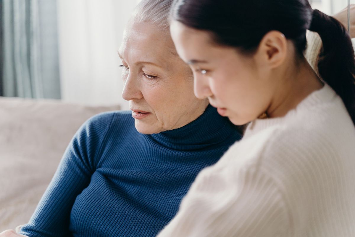 A mother and her adult daughter reviewing paperwork side by side